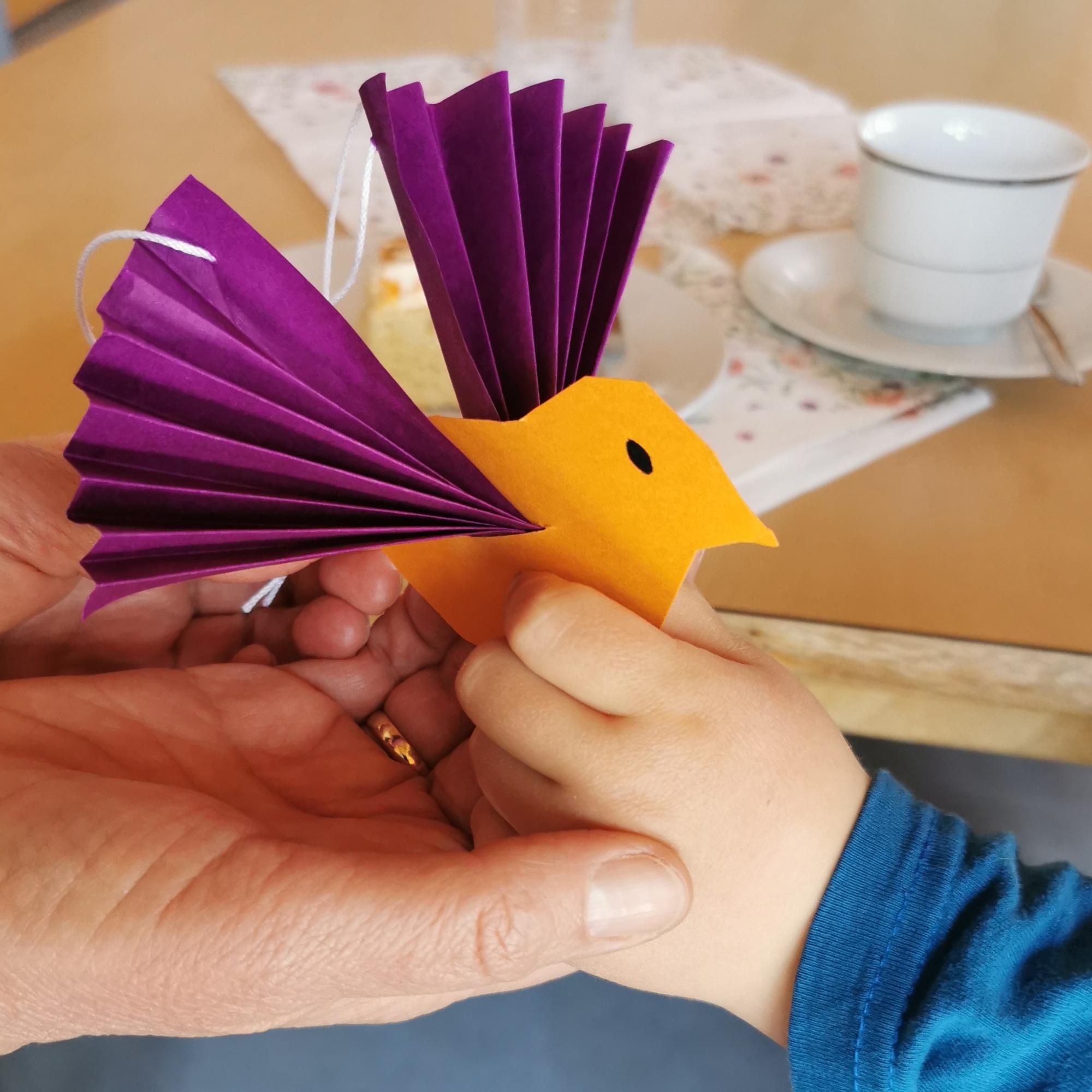 Seniorenkreis Ein Kind schenkt einen selbst gebastelten Vogel